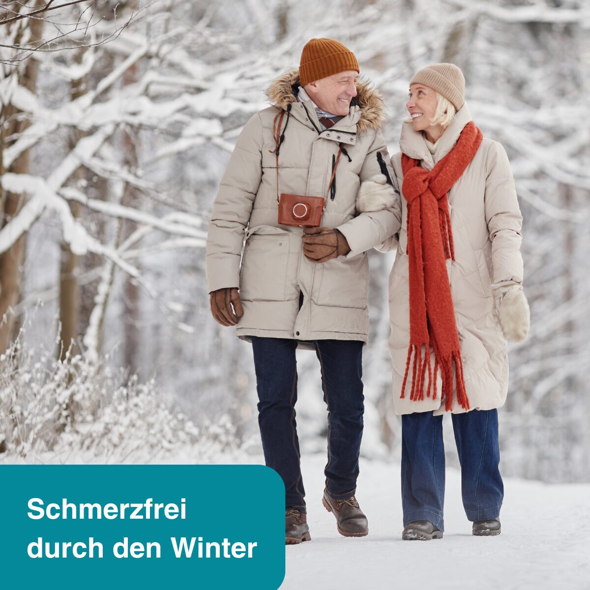 Ein Ehepaar läuft durch einen Wald, der mit Schnee bedeckt ist.